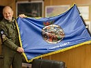 Oberst P. mit der Fahne der "Headquarters Support Group".