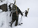 Entlang eines Felsgrates gehen Soldaten in Richtung Gipfel. (Bild öffnet sich in einem neuen Fenster)