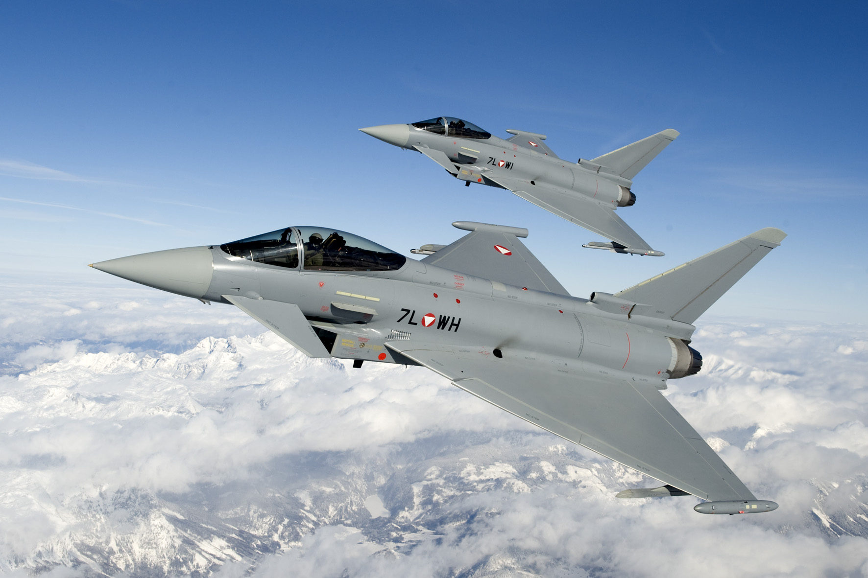 Zwei Eurofighter fliegen über verschneiten Bergen im Westen Österreichs.