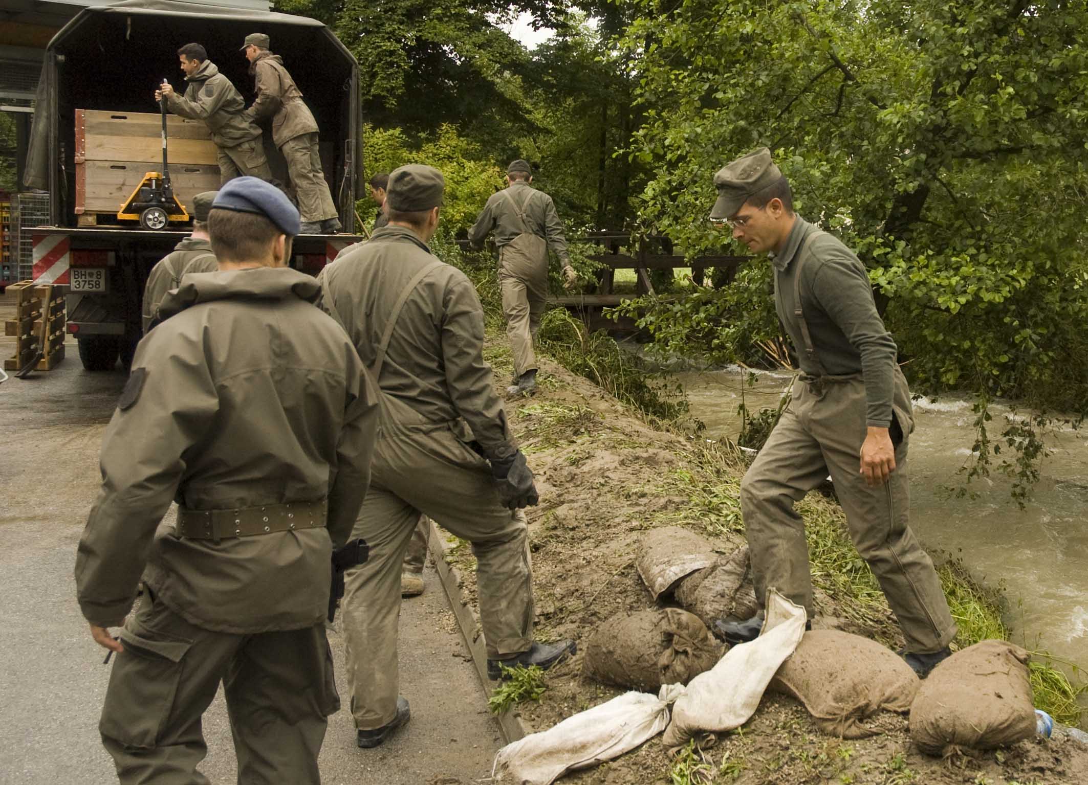 Soldaten sind nach einem Hochwasser im Einsatz am Ufer eines Baches 