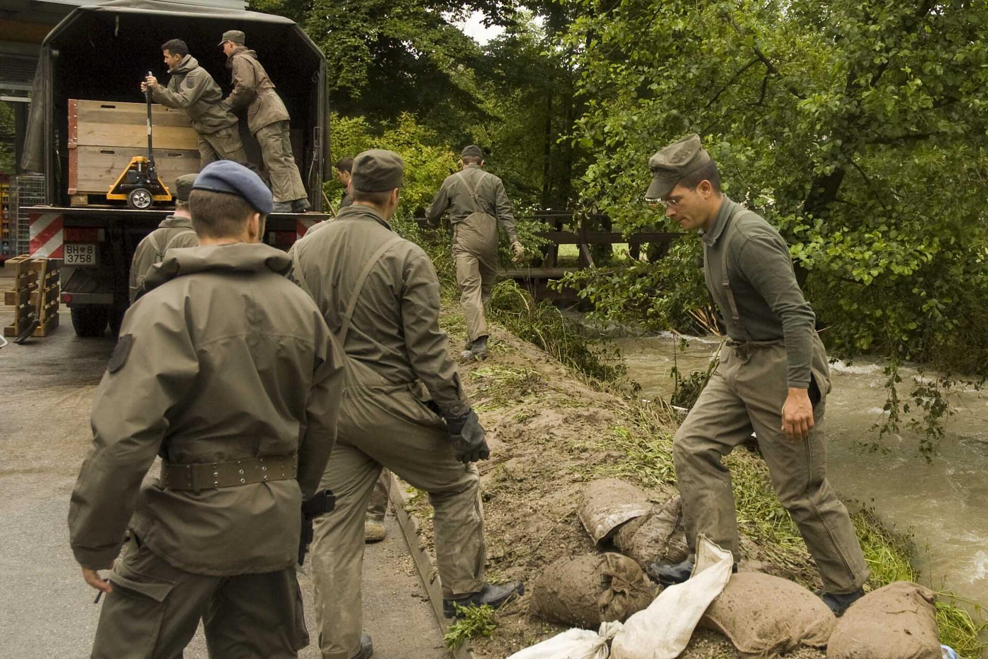 Soldaten sind nach einem Hochwasser im Einsatz am Ufer eines Baches 