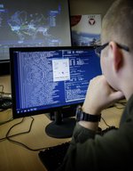 Ein Cyber-Soldat vor einem PC-Bildschirm.