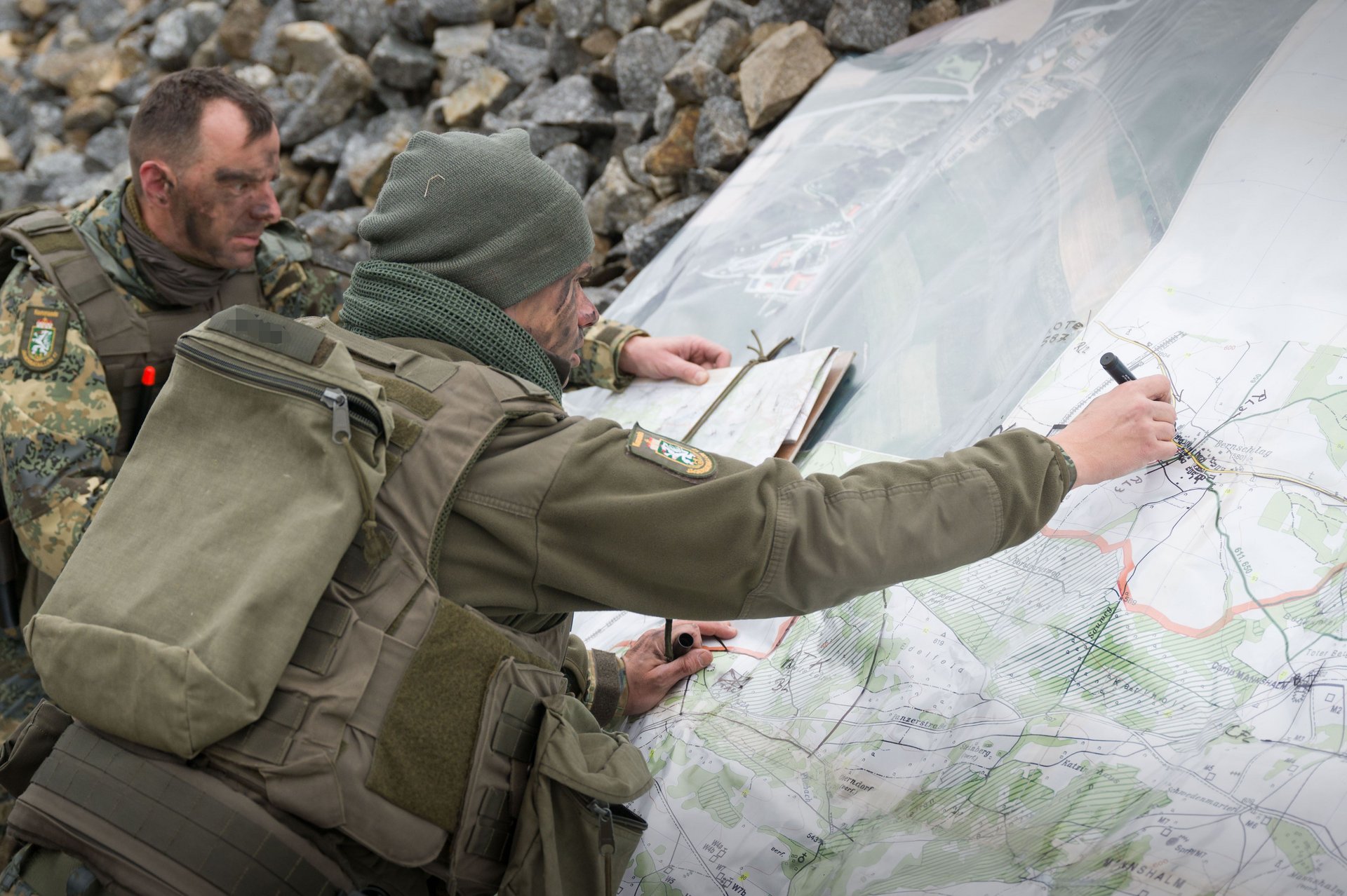 Soldaten zeichnen auf einer Lagekarte Informationen ein.