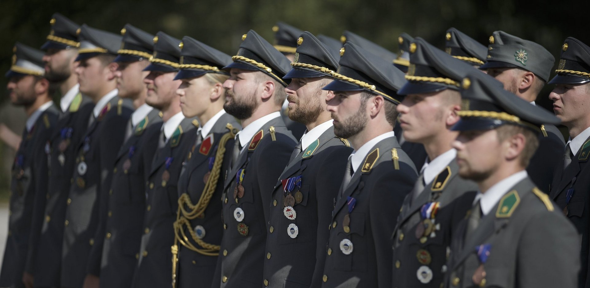 Officers in parade uniforms stand to attention.