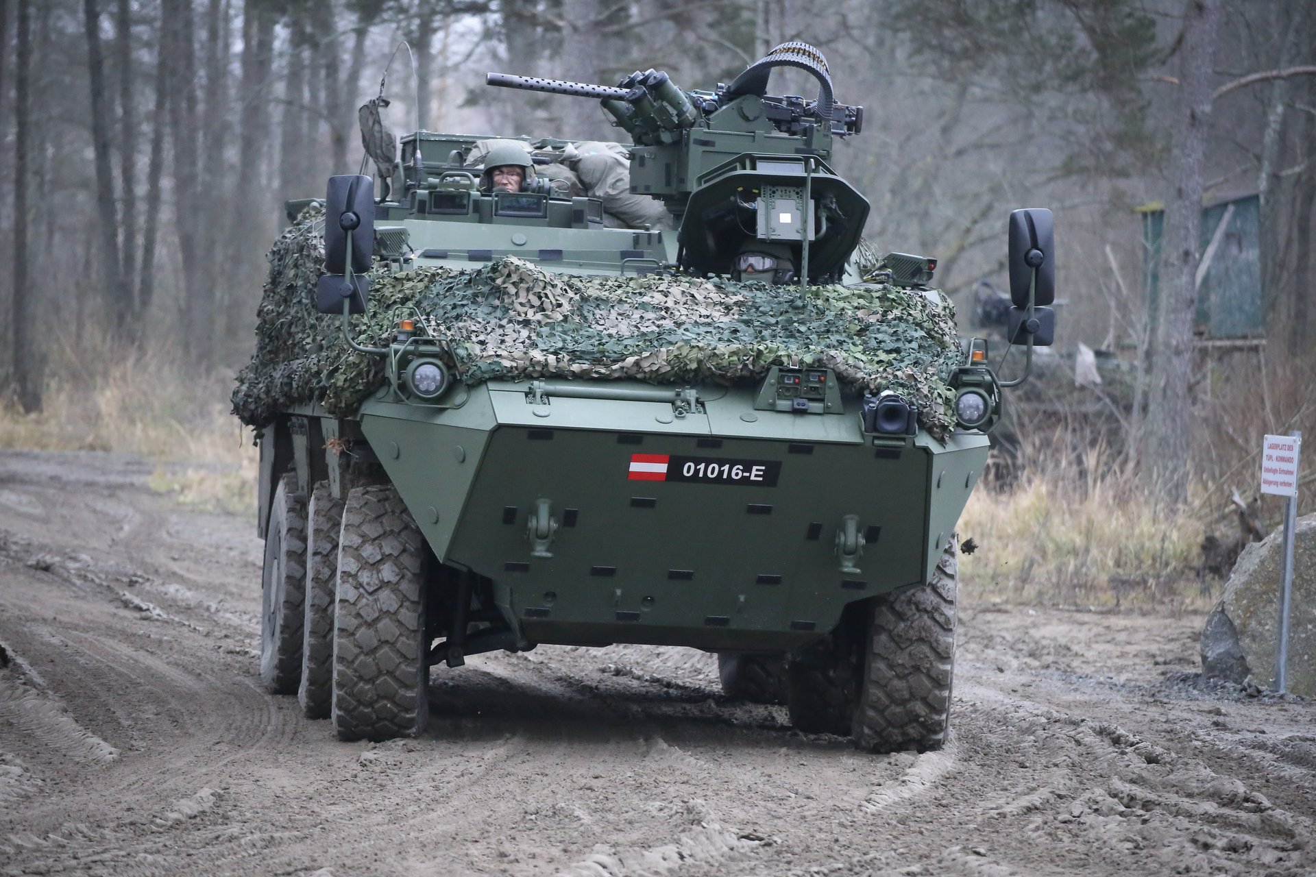 Ein Radpanzer fährt einen Forstweg entlang.