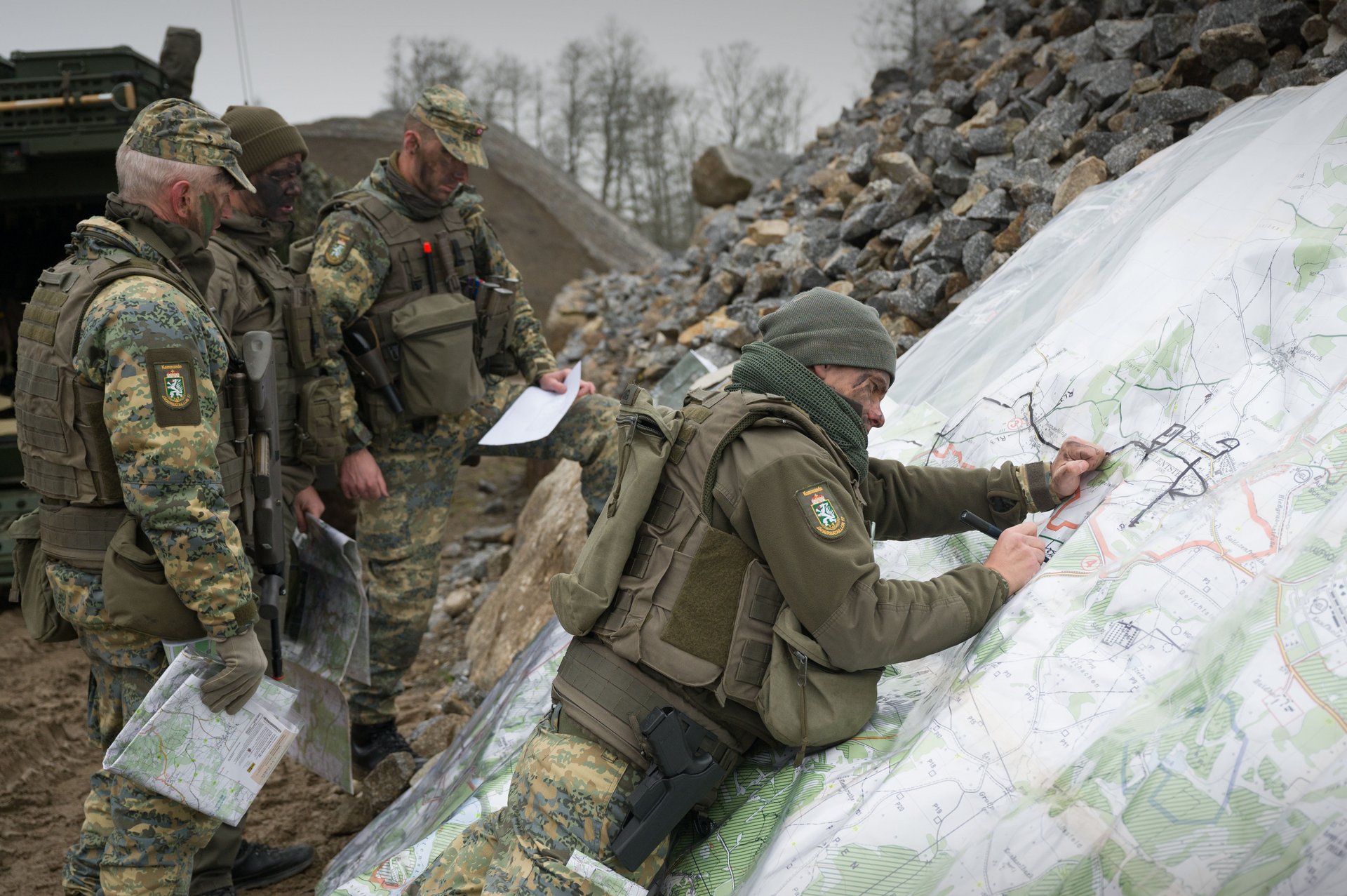 Soldaten zeichnen auf einem übergroßen Plan wichtige Punkte ein.
