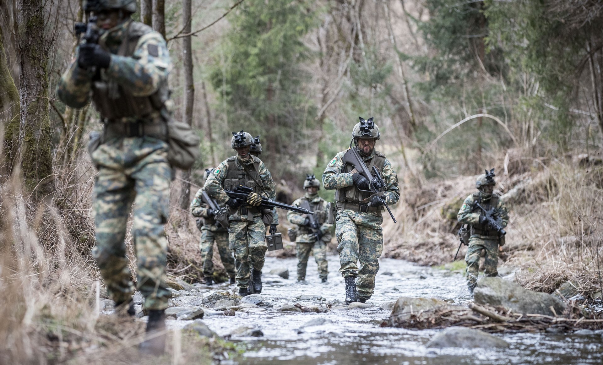 Soldaten gehen in einem Bach vor.