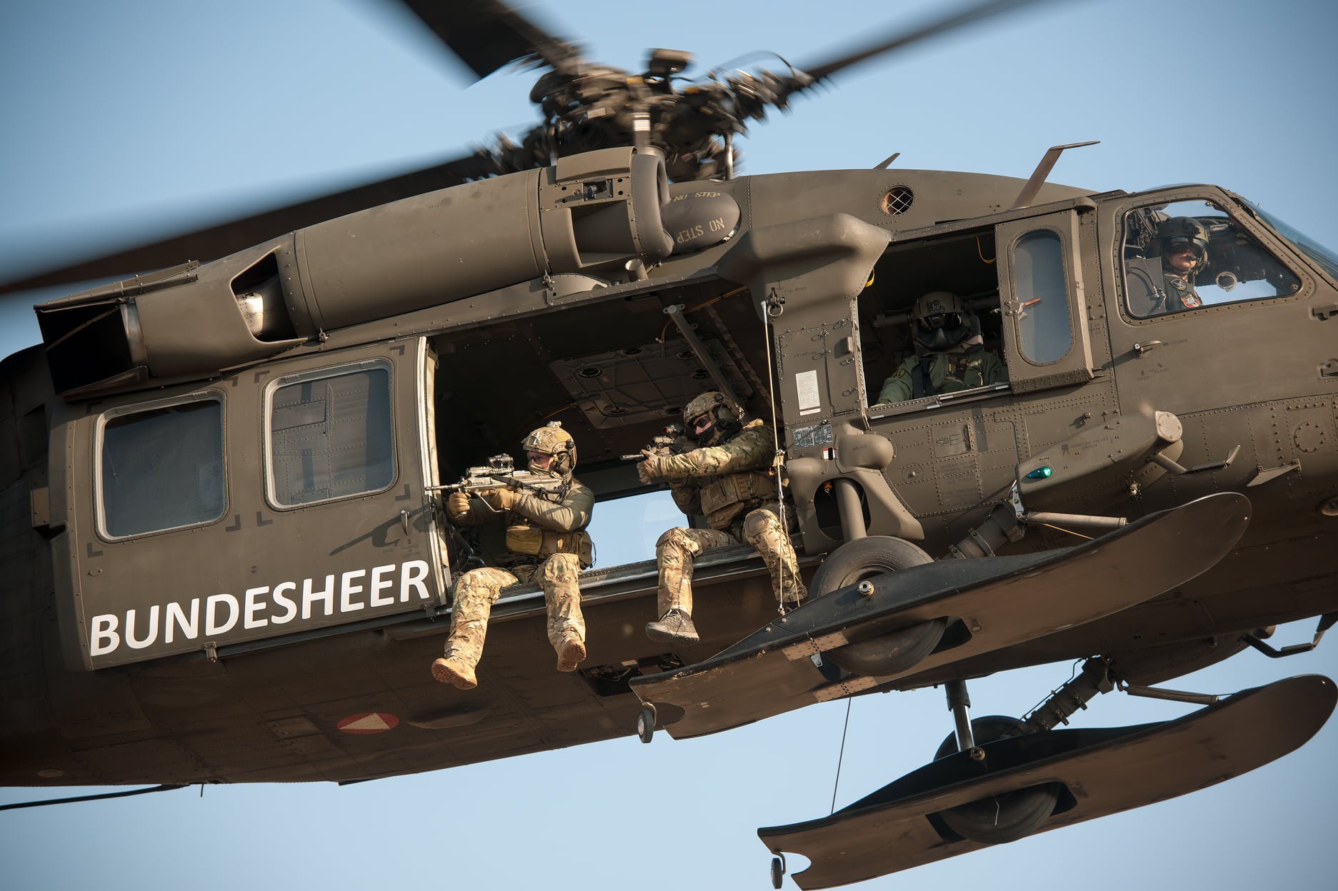 Soldaten des Jagdkommandos feuern aus einem Hubschrauber.