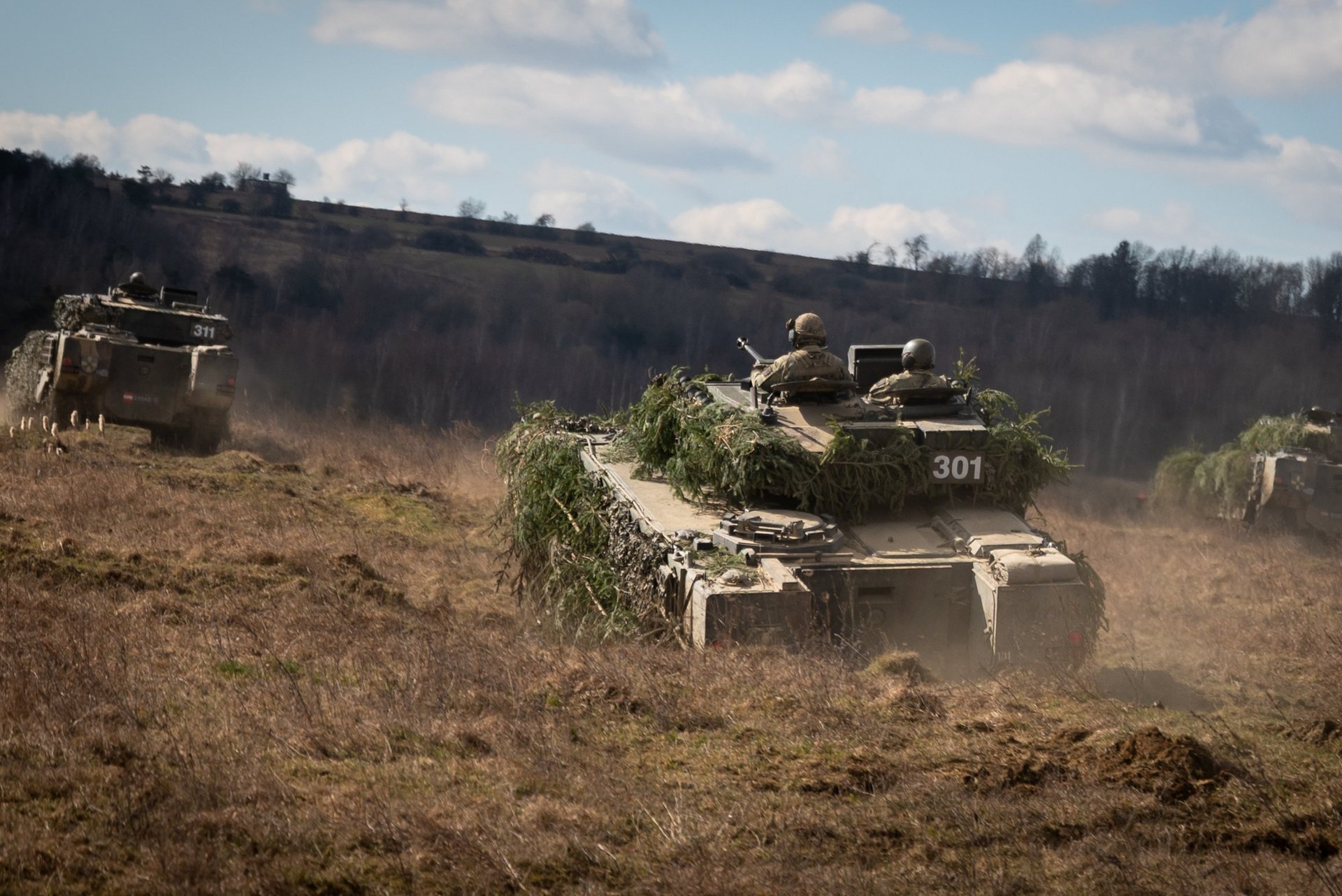 Schützenpanzer fahren durch das Gelände eines Übungsplatzes