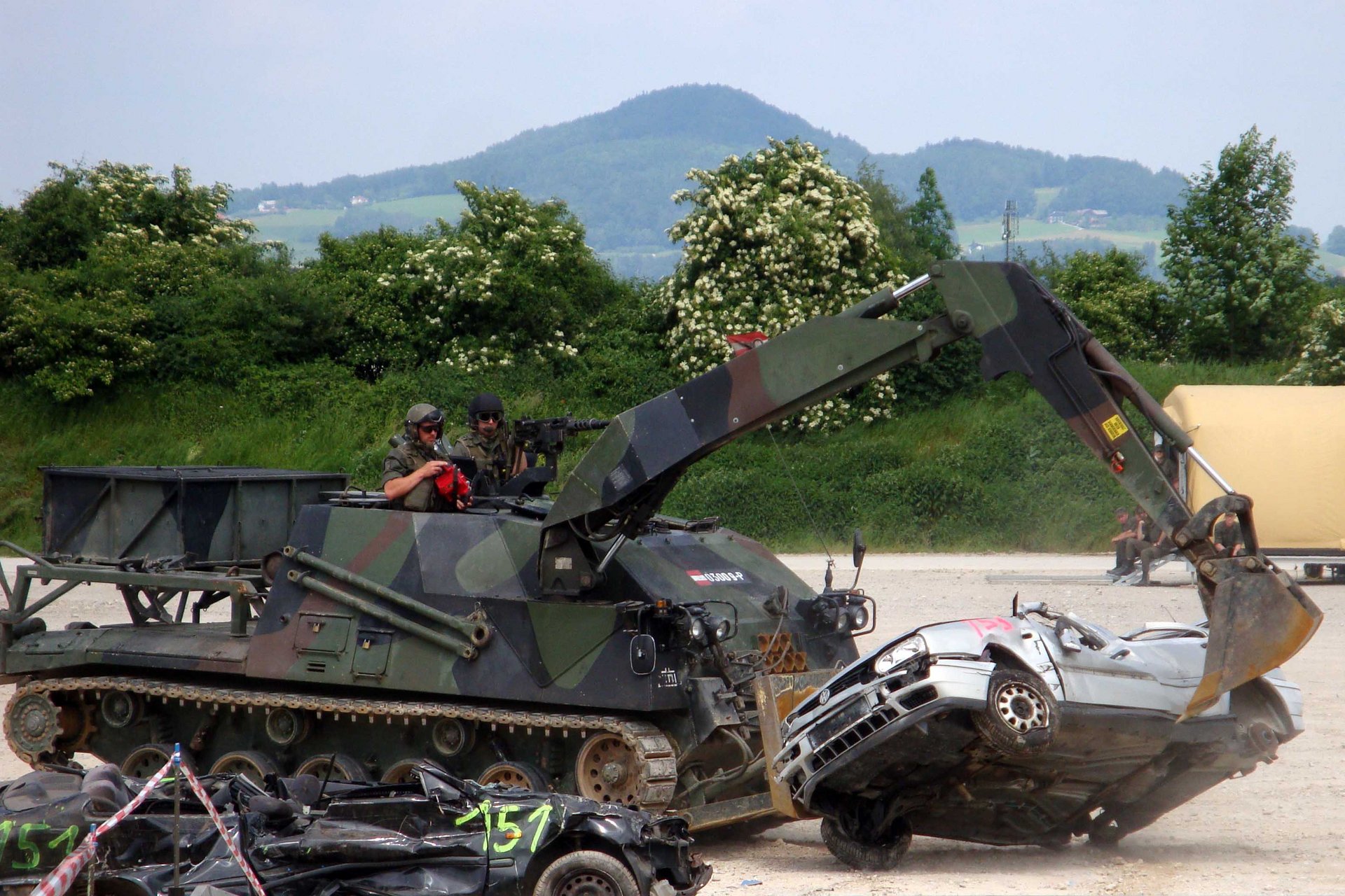 Ein Pionierpanzer räumt bei einer Vorführung einen Pkw zur Seite.