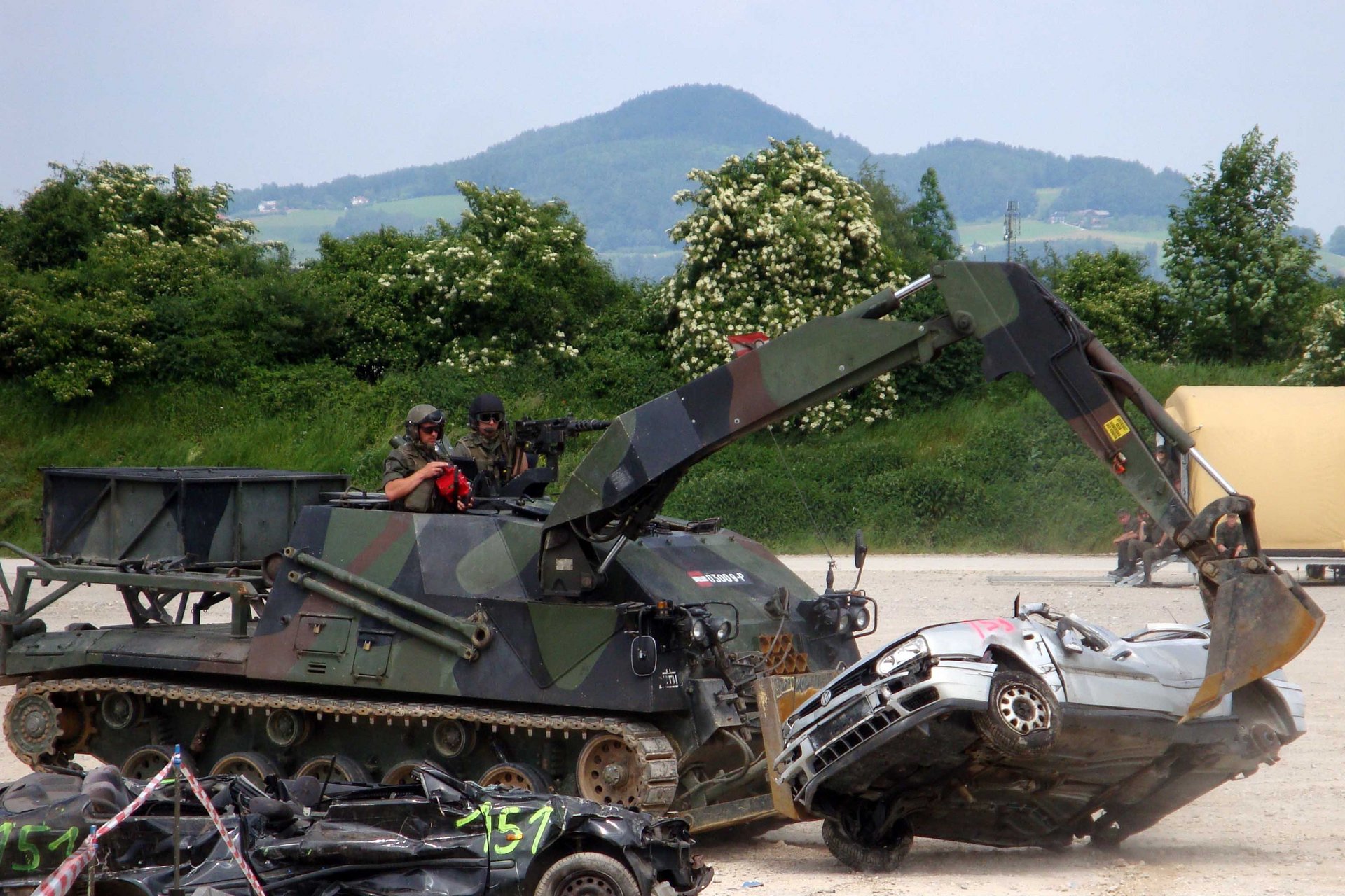 Ein Pionierpanzer räumt bei einer Vorführung einen Pkw zur Seite.