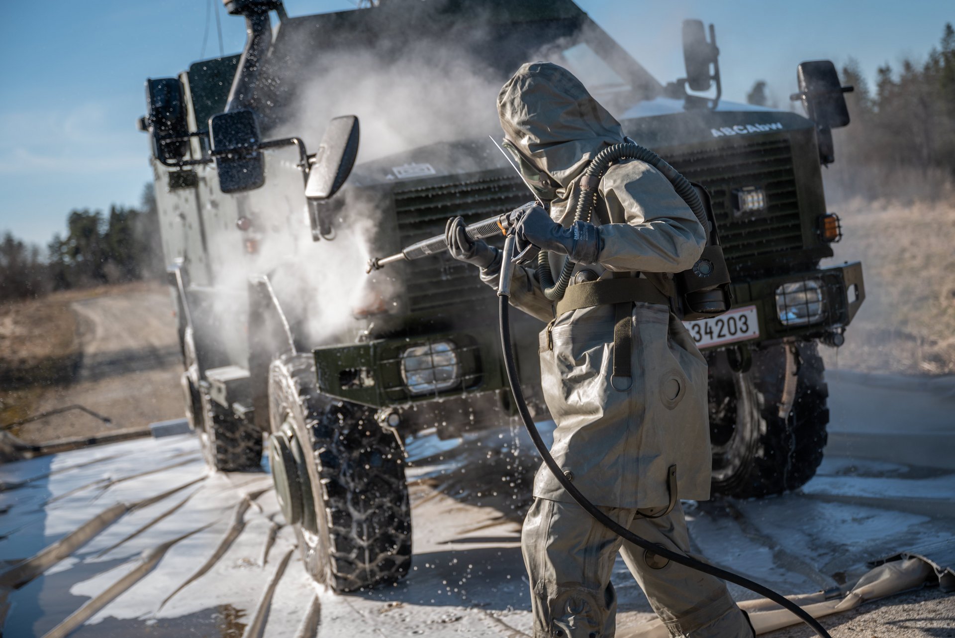 Ein Soldat der ABC-Abwehr dekontaminiert ein Fahrzeug.