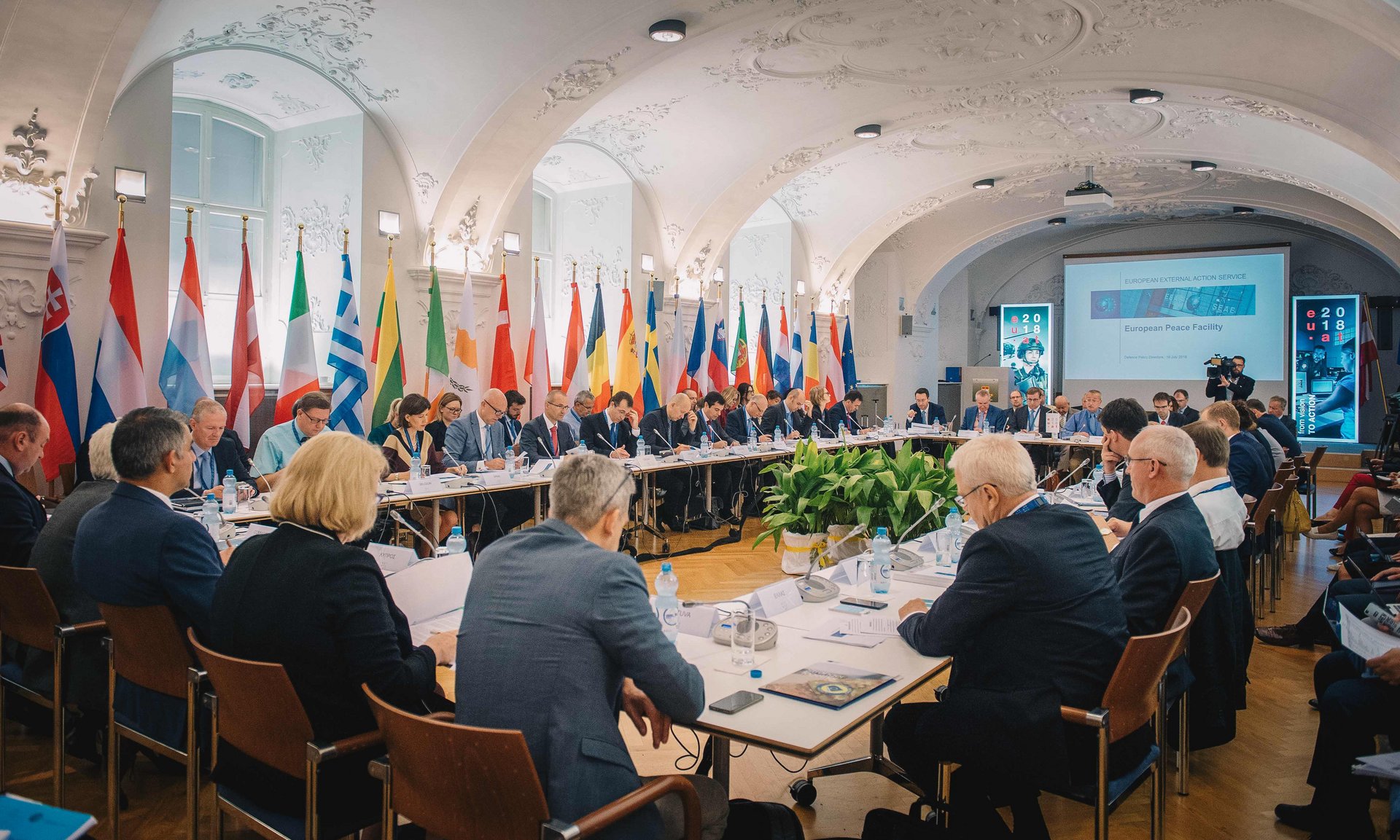 Delegates of European nations sit around a table to discuss security issues.