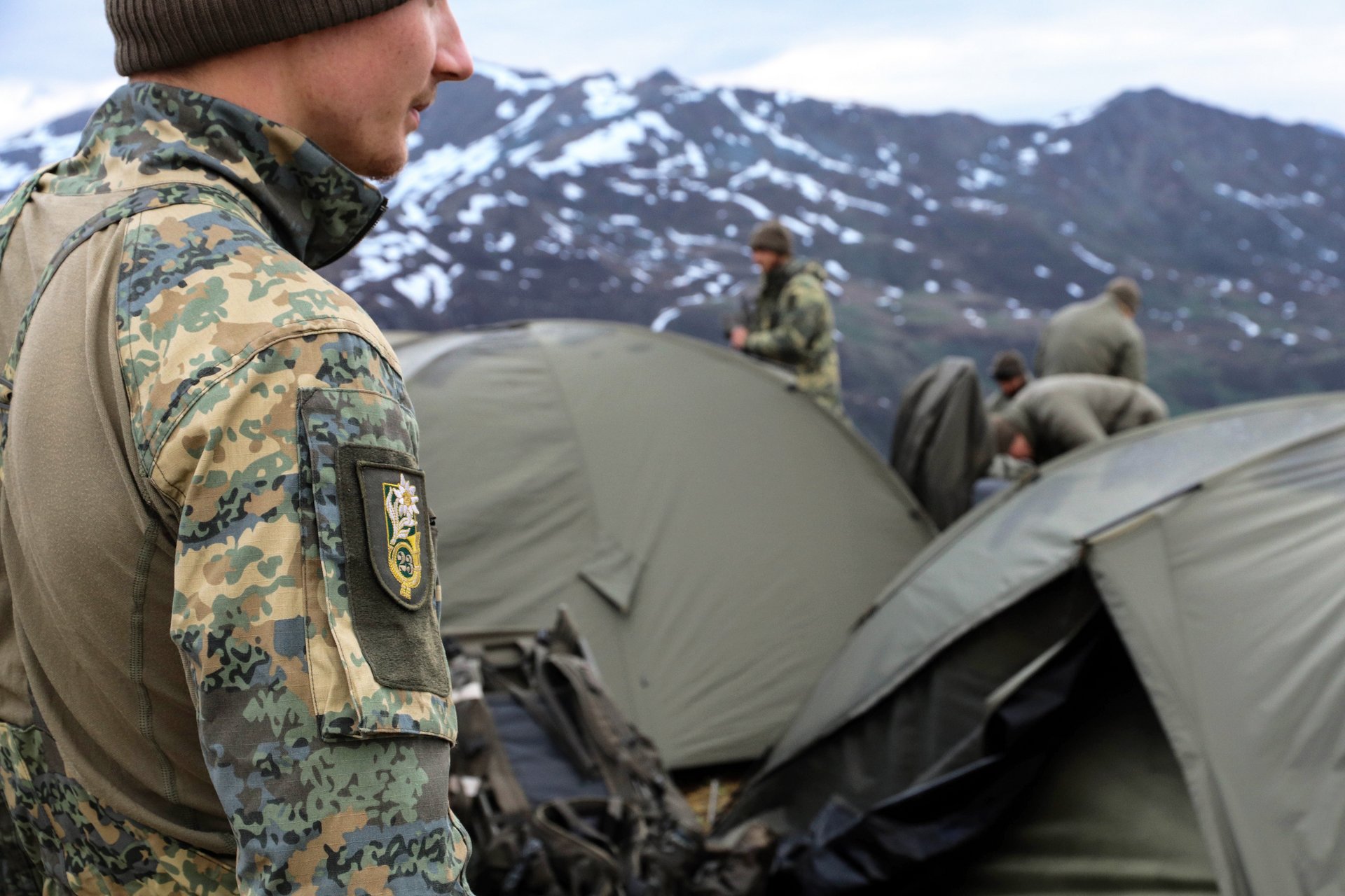 Soldaten haben im Gebirge ein Zeltlager errichtet.