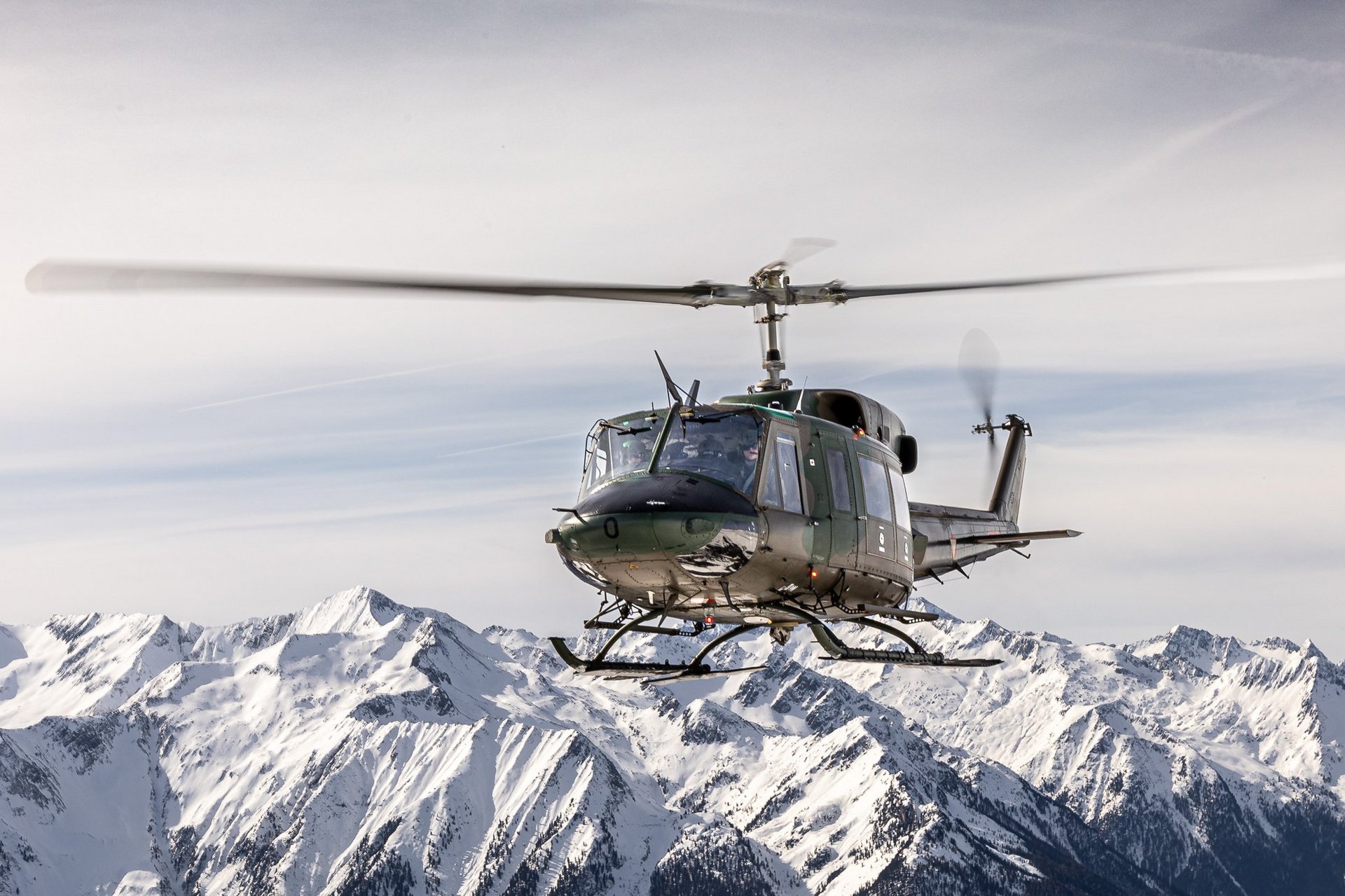 Ein Transporthubschrauber AB-212 bei einem Flug im Gebirge.