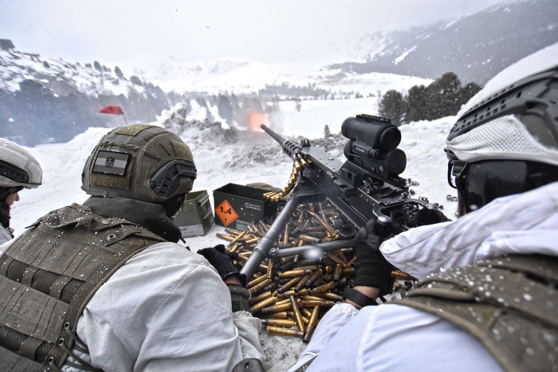 In weißer Winterkleidung getarnte Mitglieder der Infanterie üben das Schießen mit dem überschweren Maschinengewehr.