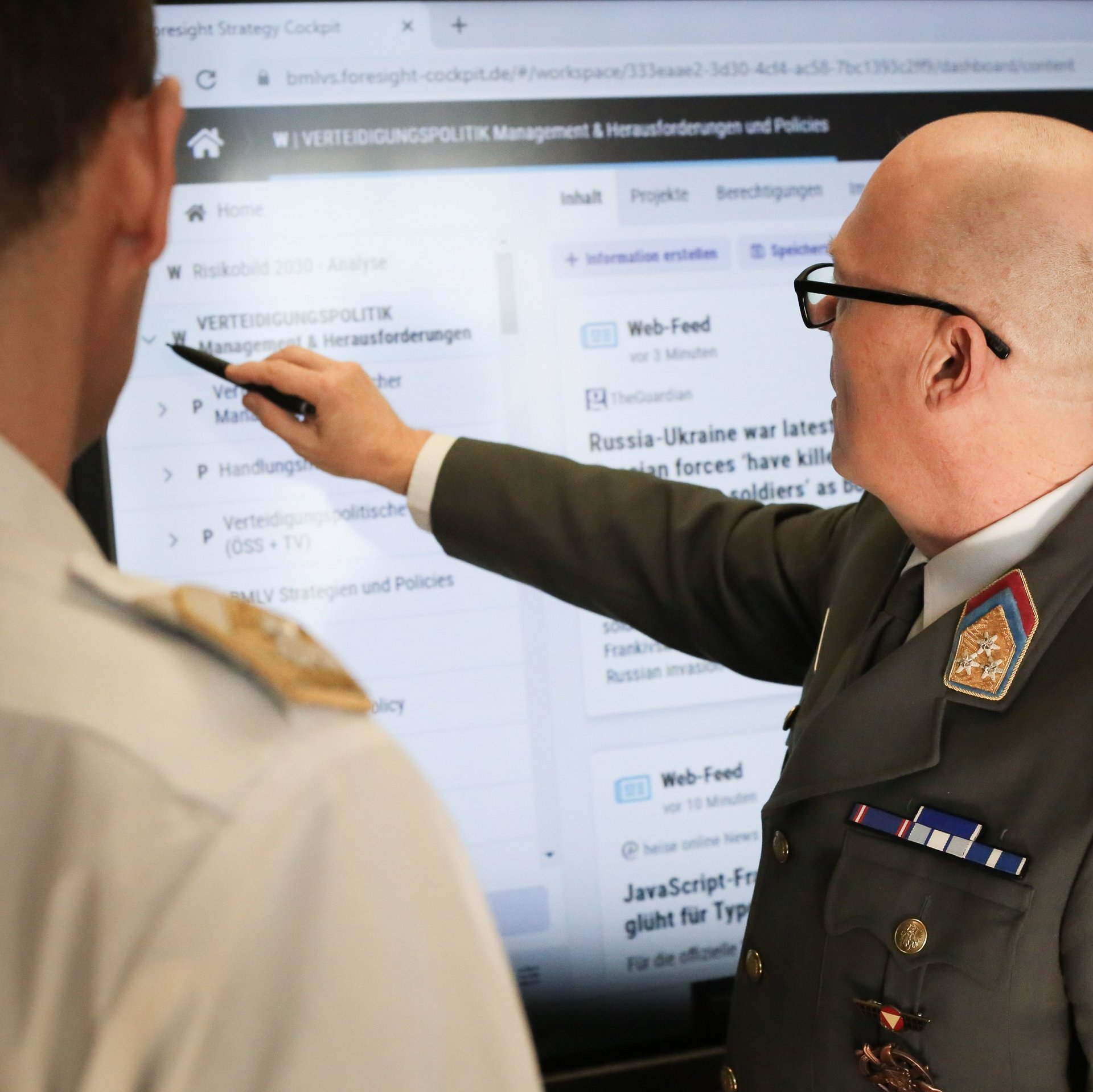 Defence policy experts discuss a security matter on a smartboard.
