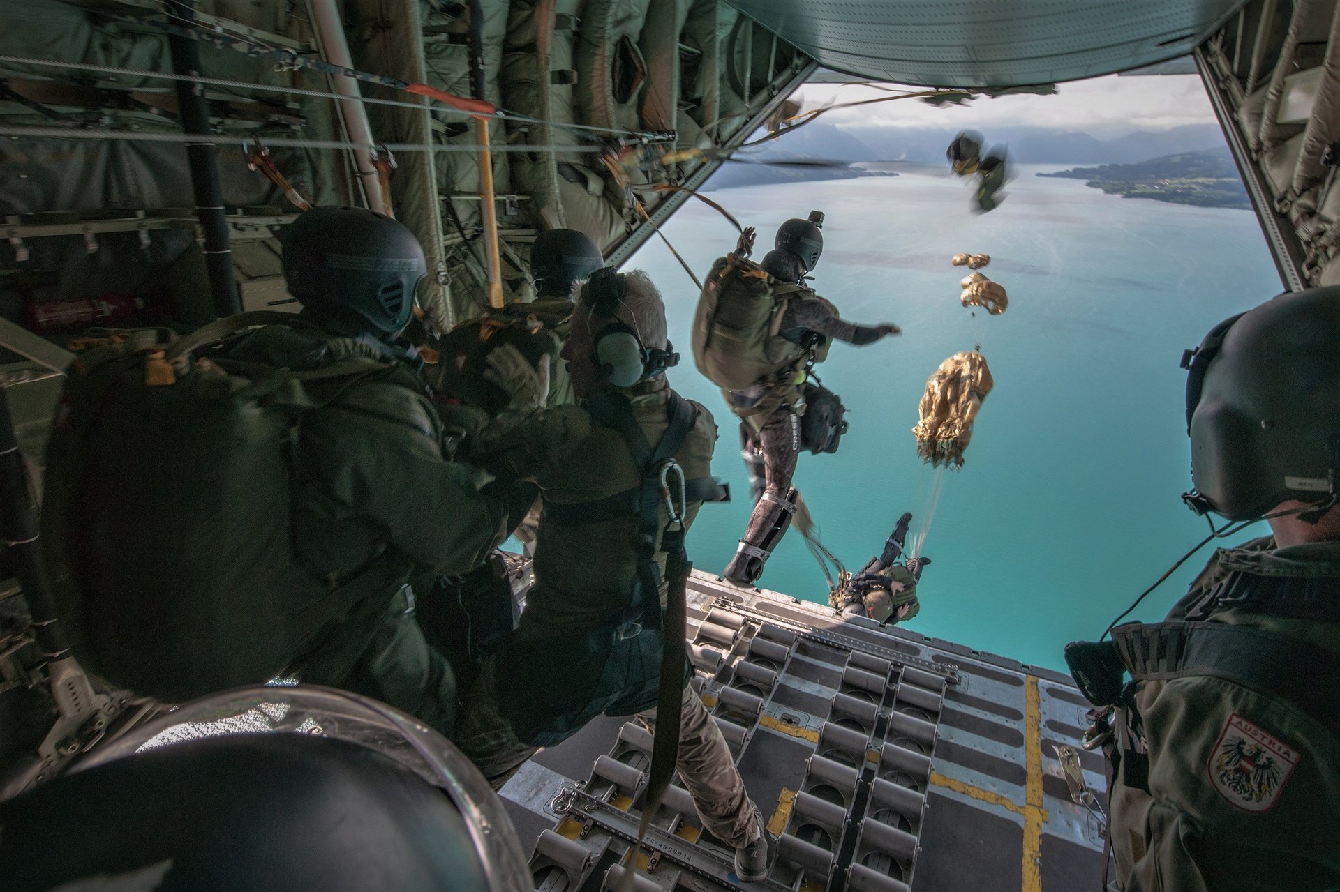 Soldaten des Jagdkommandos springen über einem See ab.