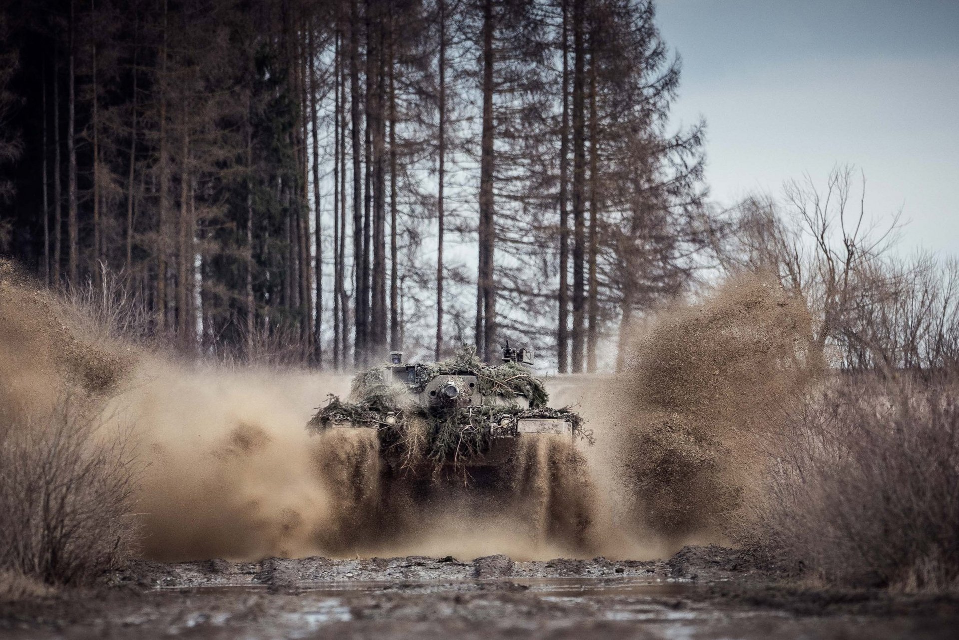 Panzer fährt durch schlammiges Gelände 