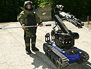 Soldat mit Schutzausrüstung und Minenräumroboter "Roland"